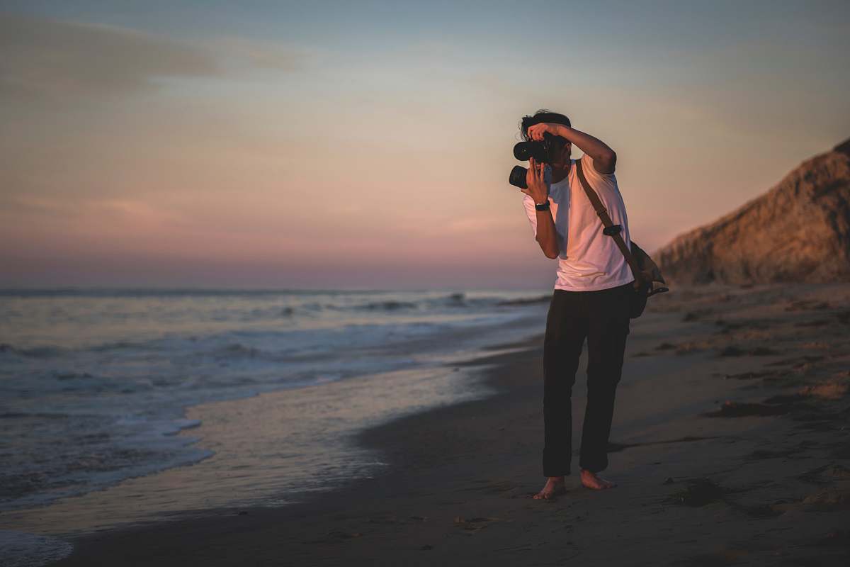 human man taking photo of seashore person