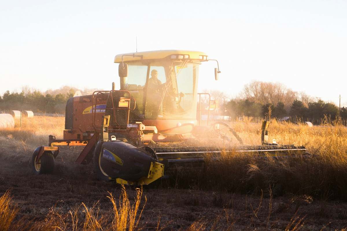 vehicle person riding brown combine harvester during daytime bulldozer