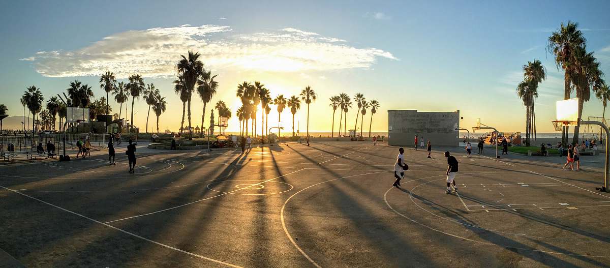 venice people playing basketball at court during sunset los angeles
