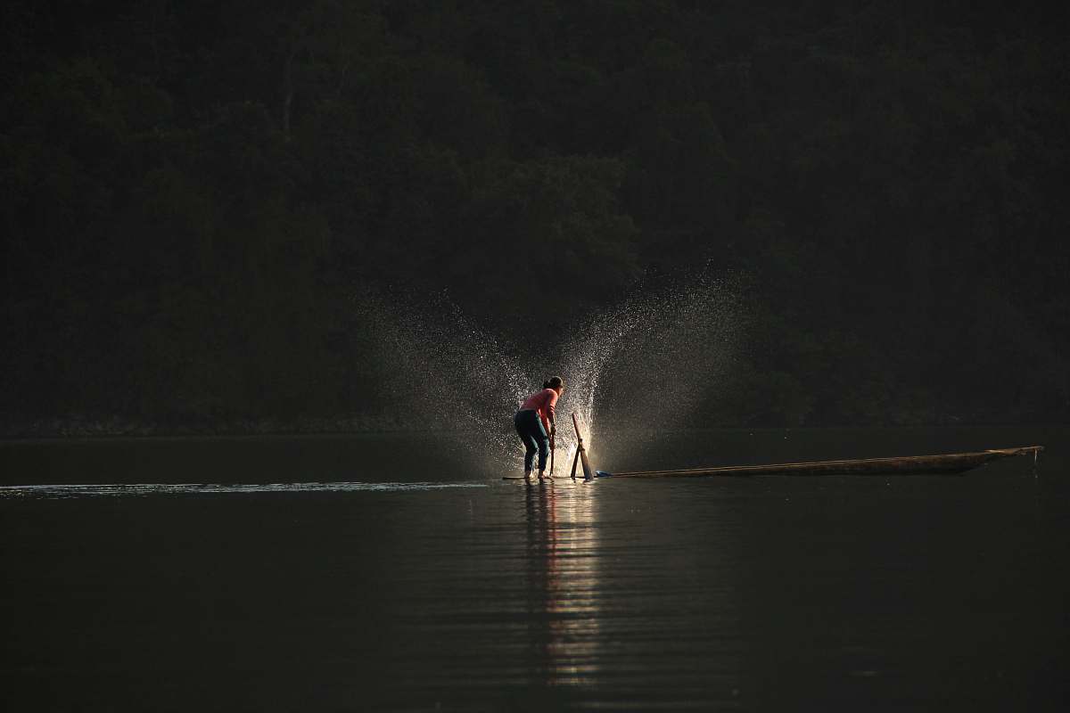 vietnam person standing on boat playing water fishing