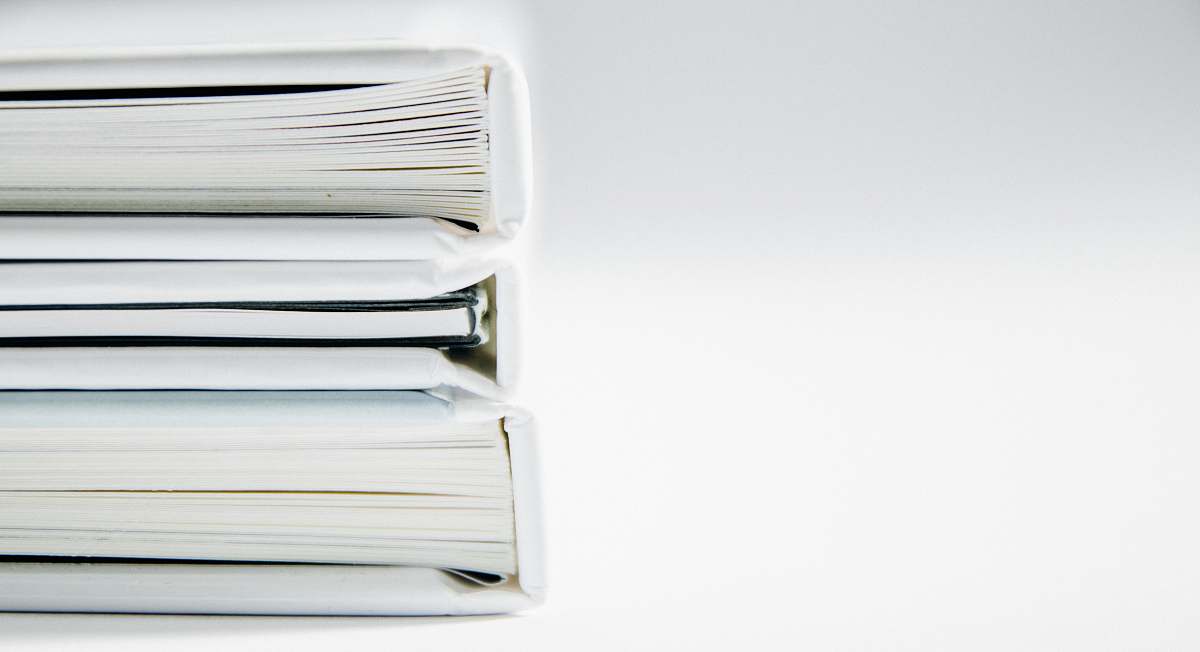 book A stack of thick folders on a white surface books