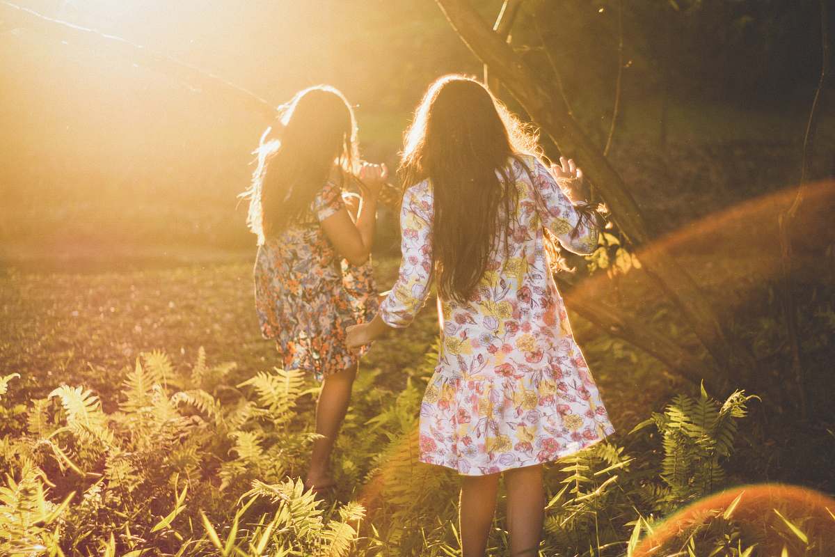 dress two women running around woods sunlight