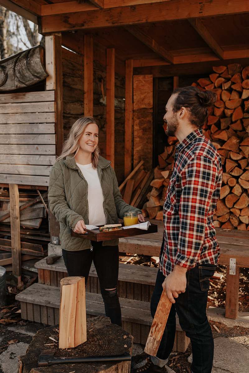  man and woman standing beside brown wooden fence 