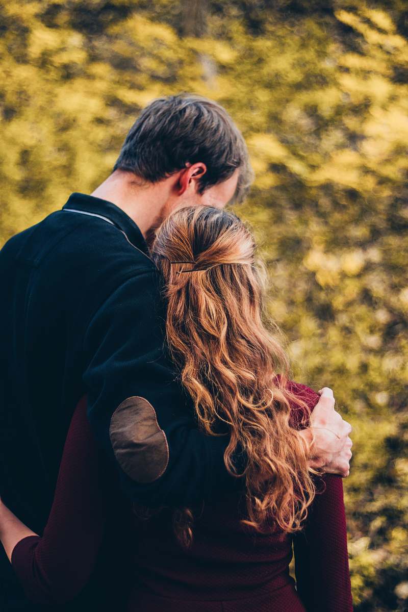 woman and man standing beside tree at daytime 
