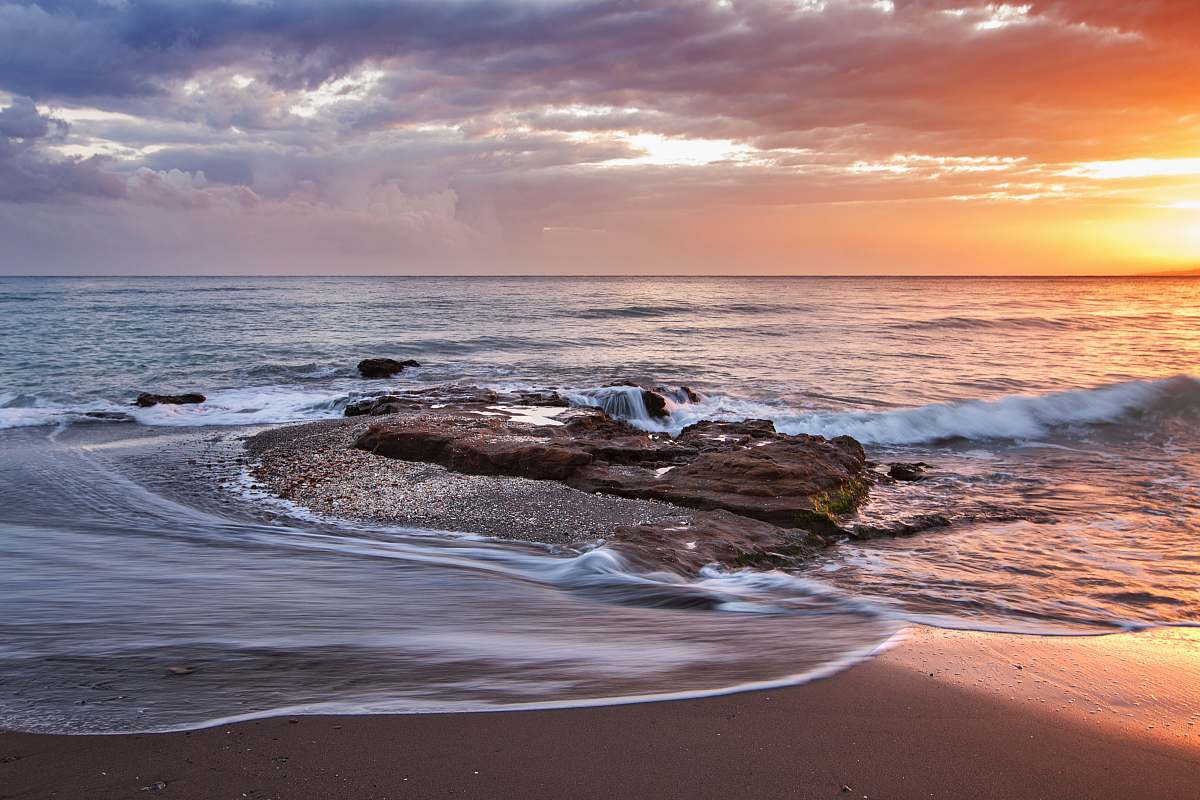 ocean brown stone near seashore during sunset coast