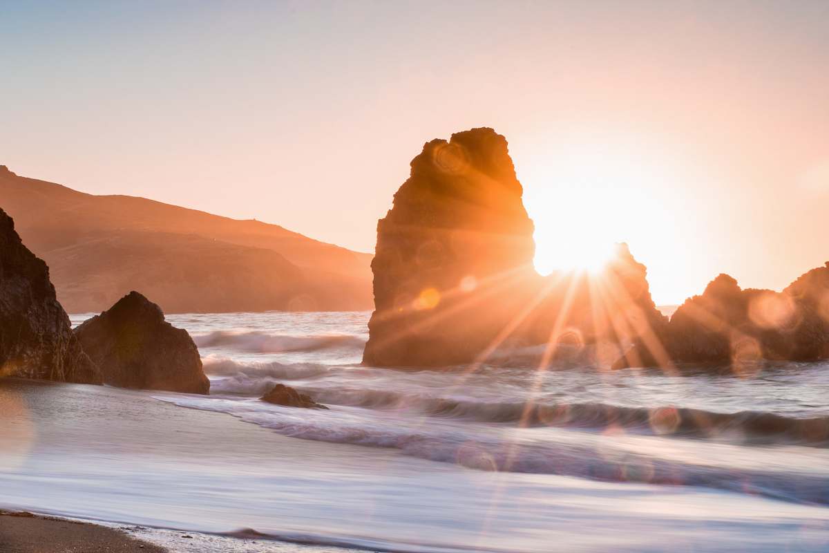 nature golden hour photography of rock formation on body of water water