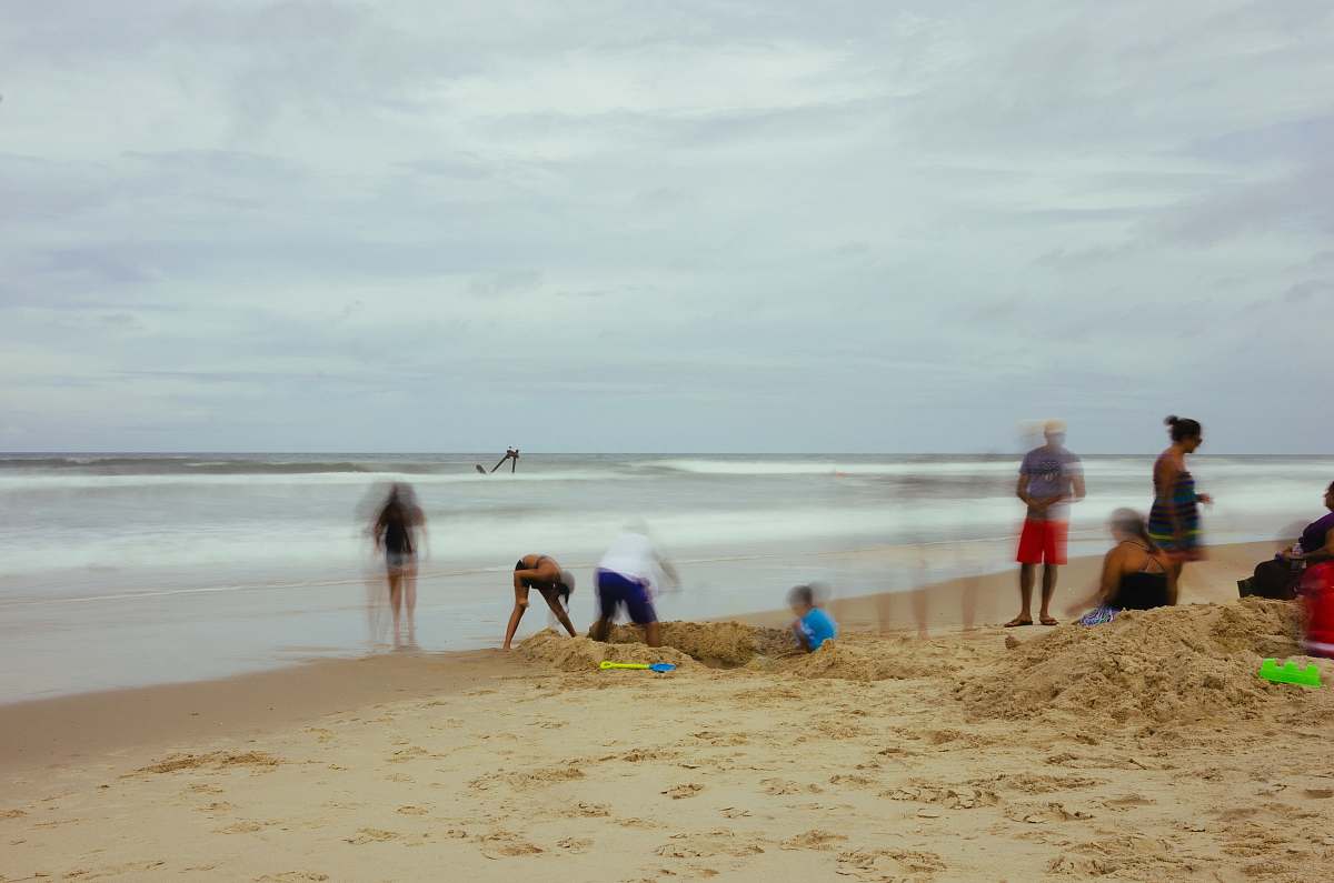 ocean group of people standing on beach shore sea
