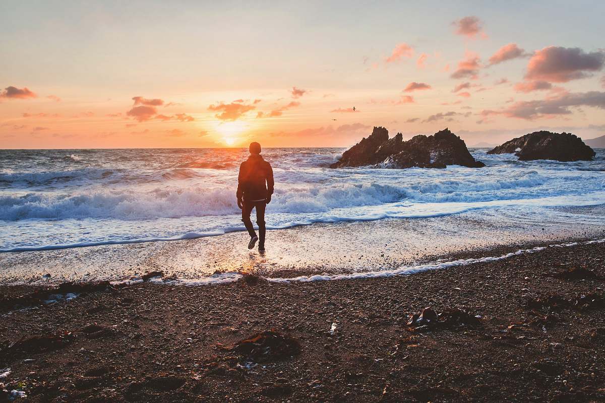 water man walking in beach during golden hour sea