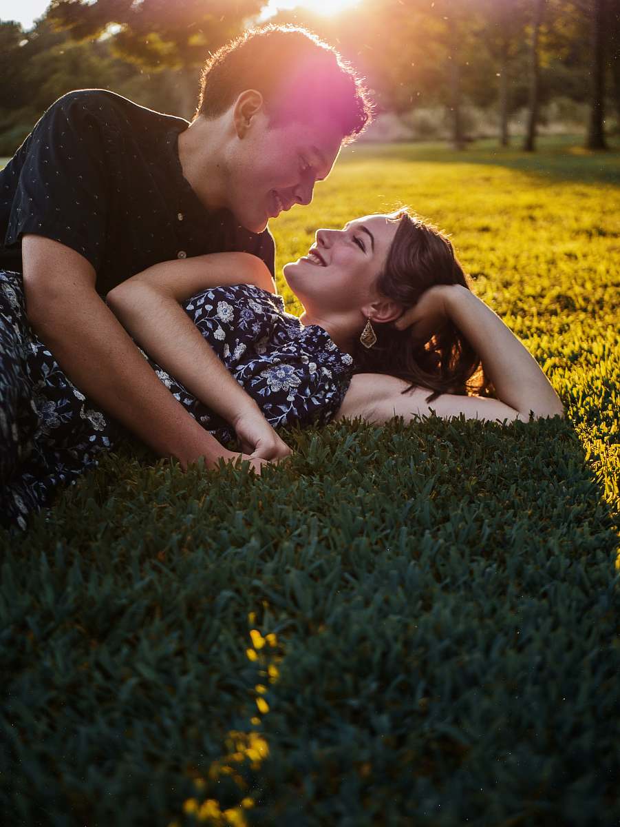 plant man and woman lying on green grass field during daytime blonde