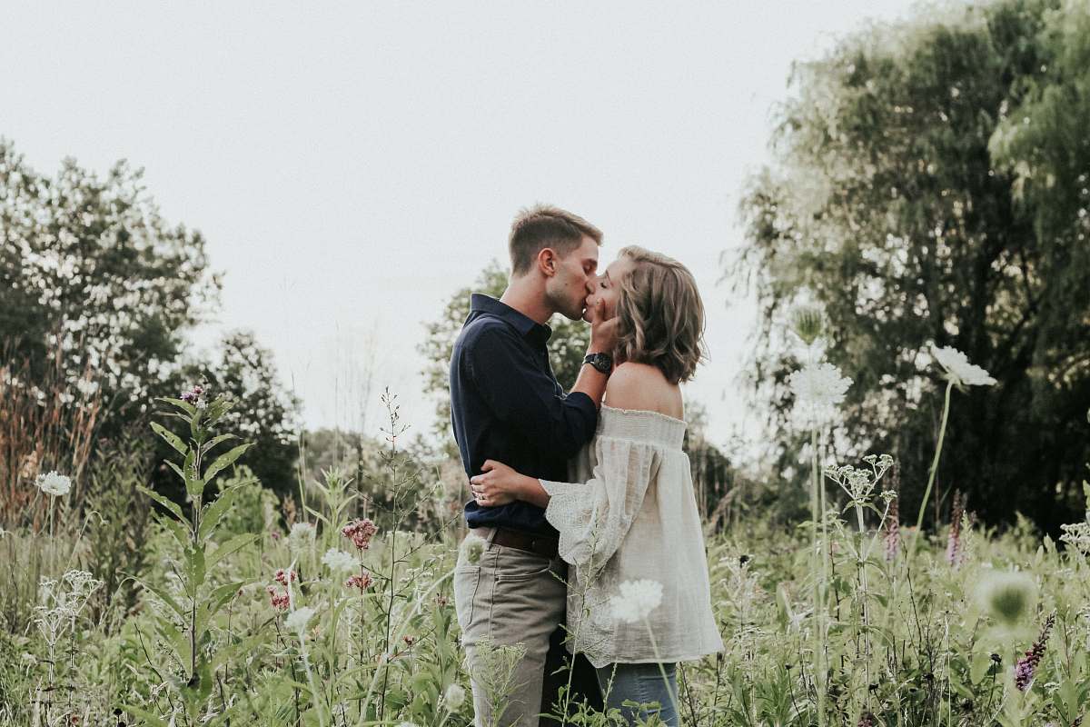 couple male and female kissing on grass field kiss