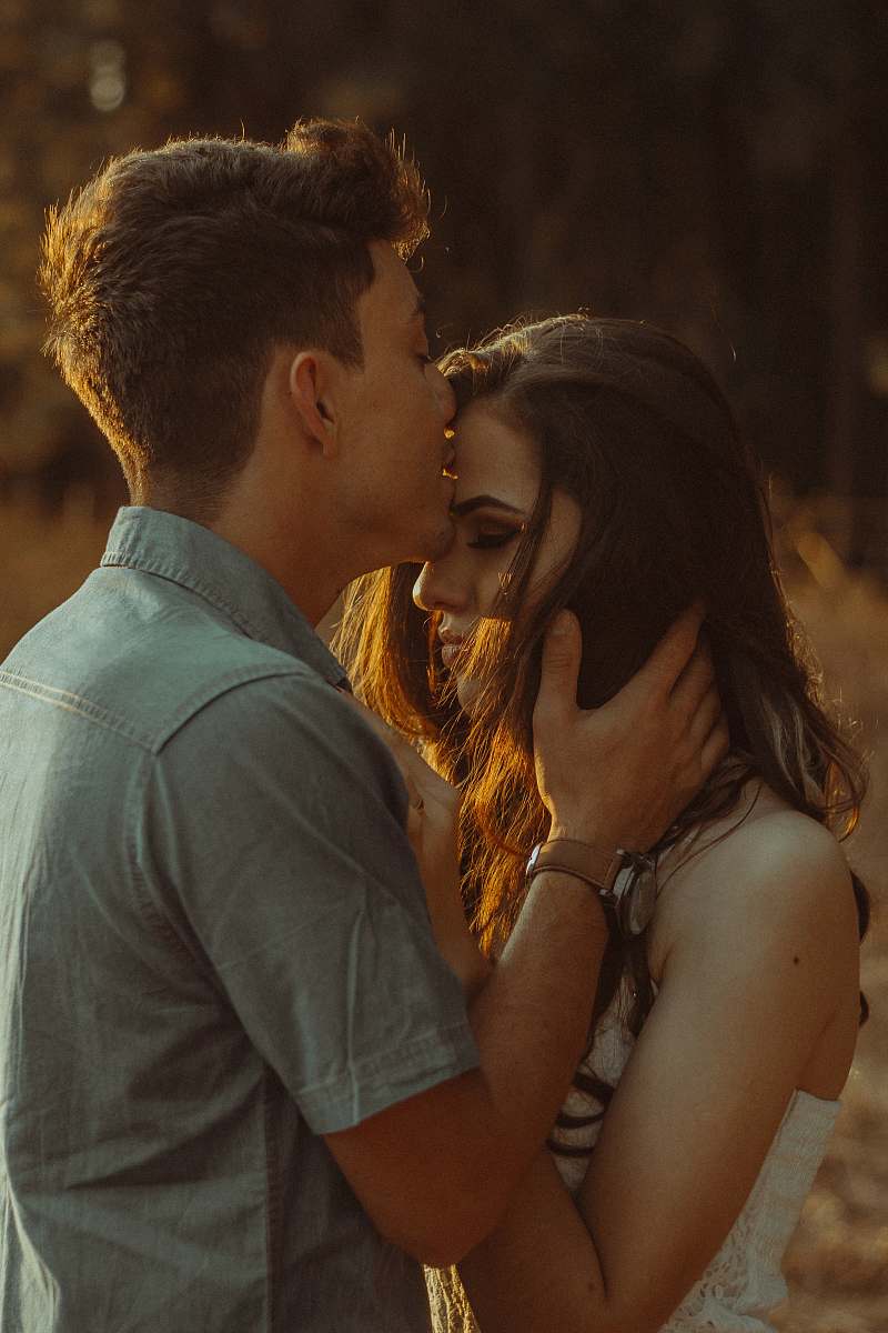 people man kissing woman forehead couple