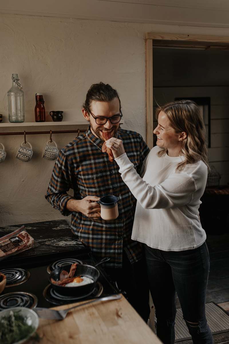 person woman in white sweater holding man in black and white checkered dress shirt shelf