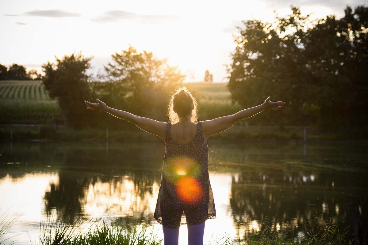 human woman standing beside lake under white sky people