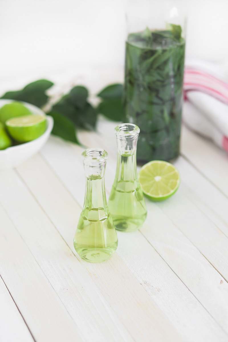 drink two clear glass bottles with lime juice on white wooden table beverage