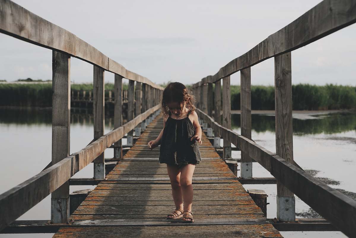 human girl wearing black camisole walking on dock person