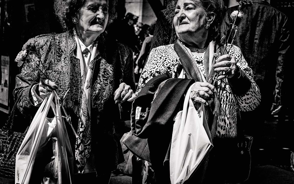 human grayscale photo of two women holding bags person