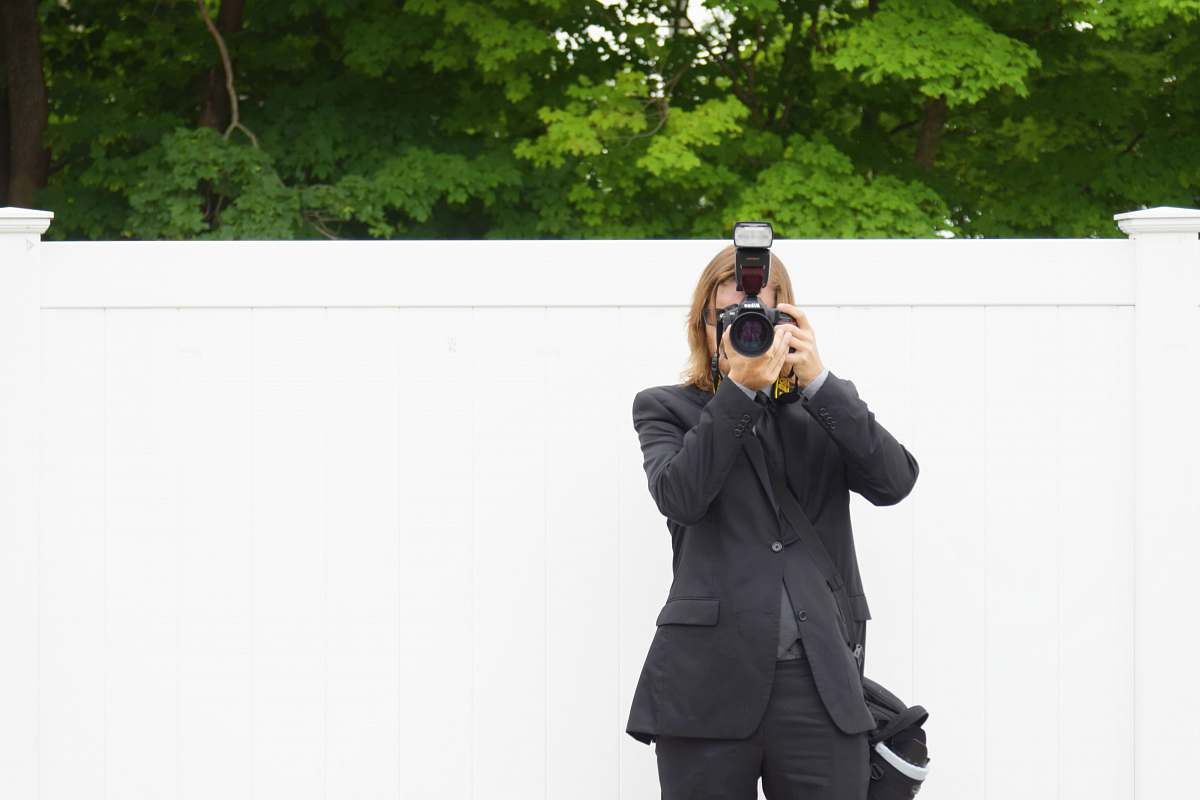 clothing person in black suit jacket using DSLR camera coat