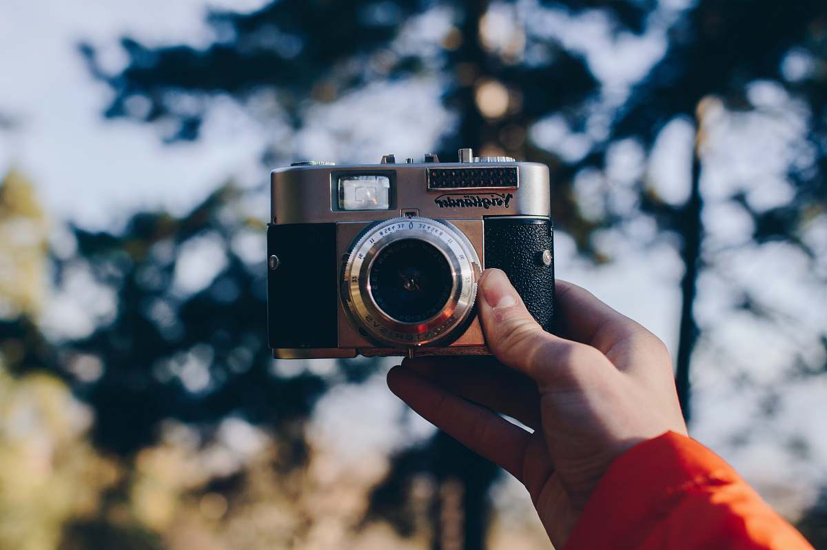 electronics person holding black and gray point-and-shoot camera 35mm camera
