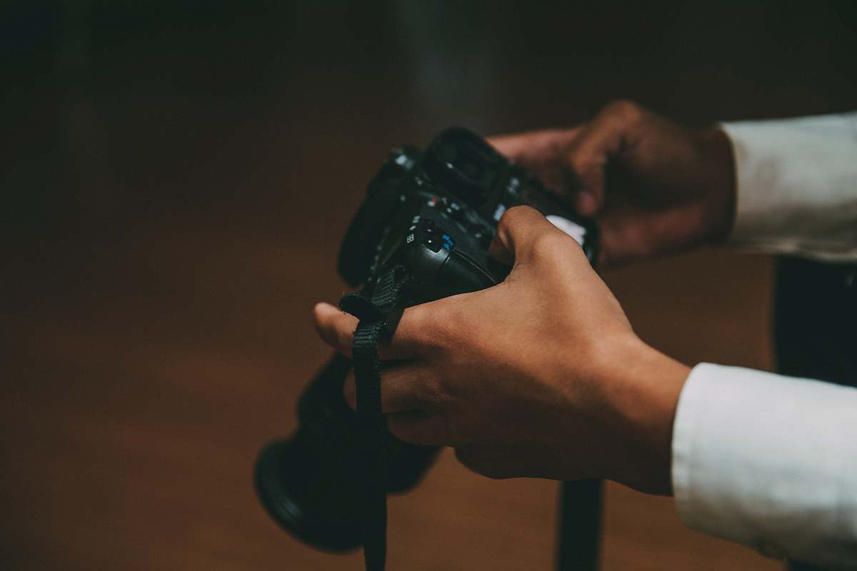 person person holding black DSLR camera human