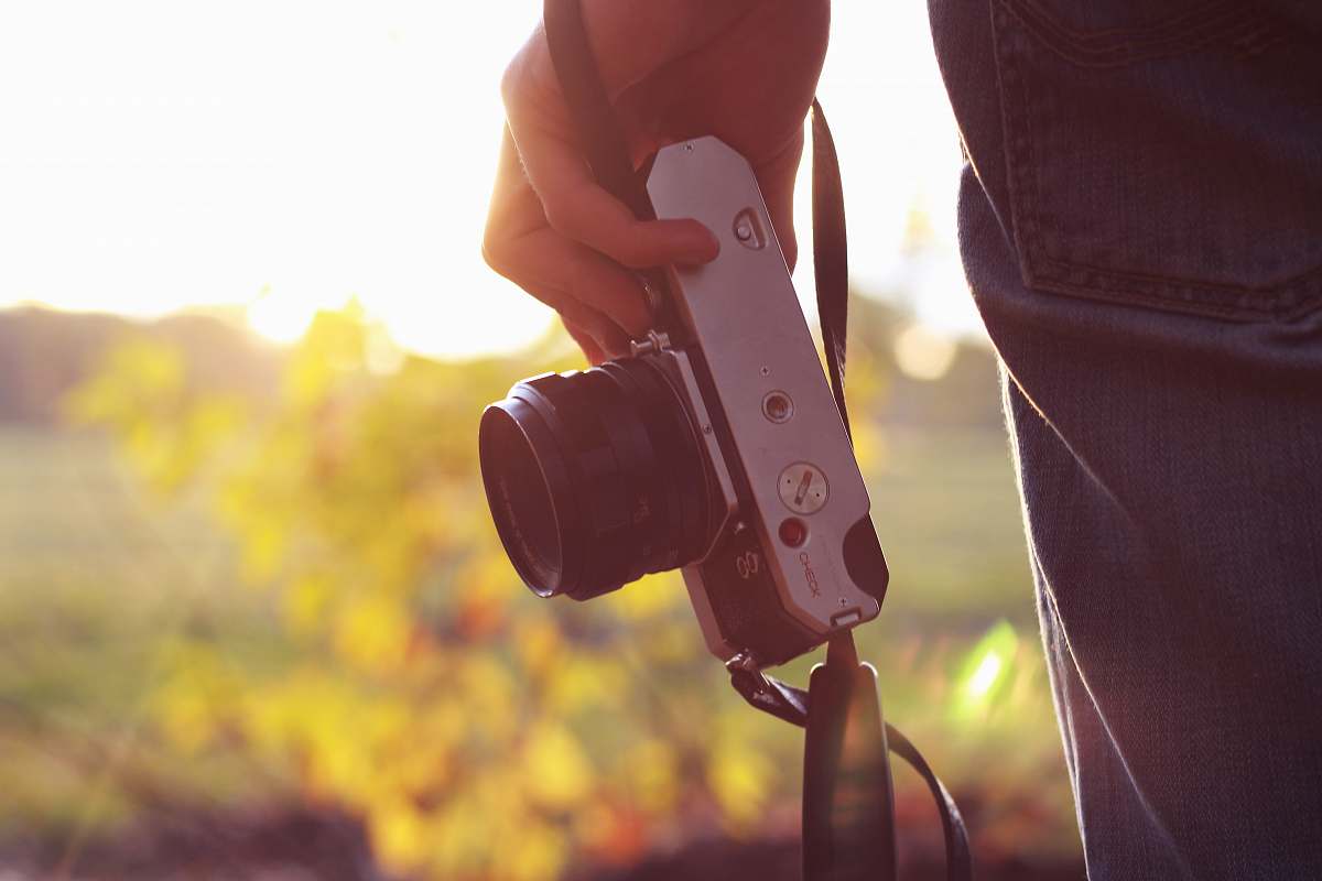 hand person holding bridge camera during daytime sunlight