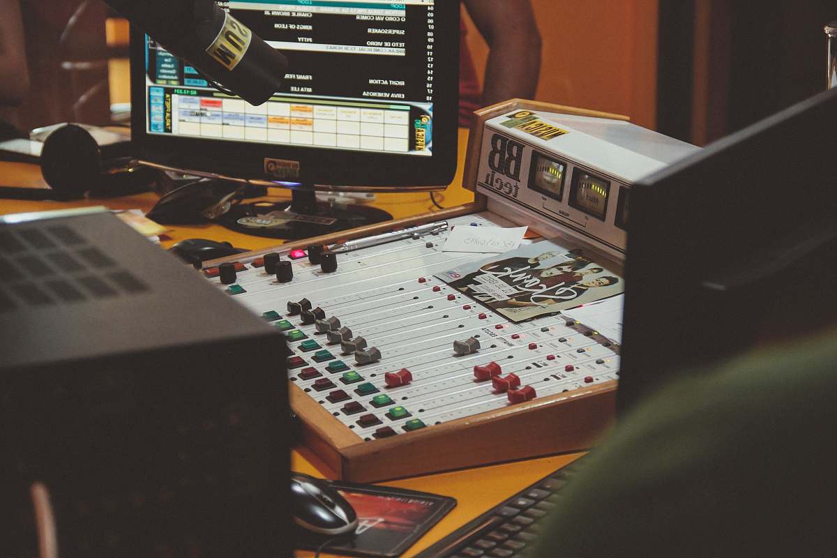 music white audio mixer beside black flat screen computer monitor hardware