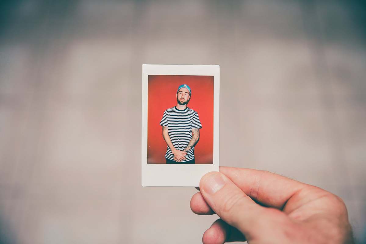 polaroid shallow focus photography of photo of man man