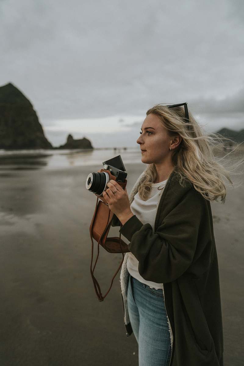 This stunning image features a woman skillfully photographing a picturesque beach, showcasing her passion for capturing the beauty of nature. The serene waves, golden sand, and vibrant sky create a perfect backdrop for any photography enthusiast or travel blog. Ideal for use in articles about travel, photography, lifestyle, or tourism, this image embodies the joy of exploring and documenting breathtaking coastal landscapes.