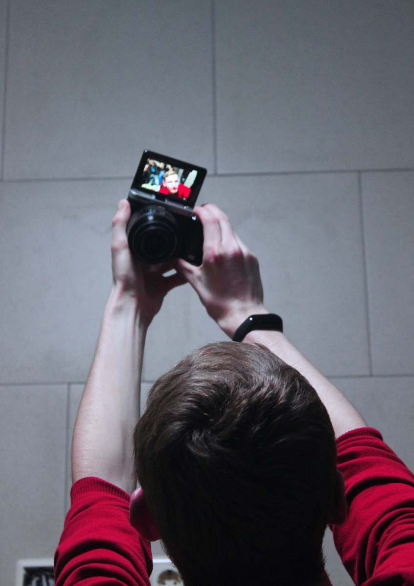 person close-up photography of man taking selfie camera