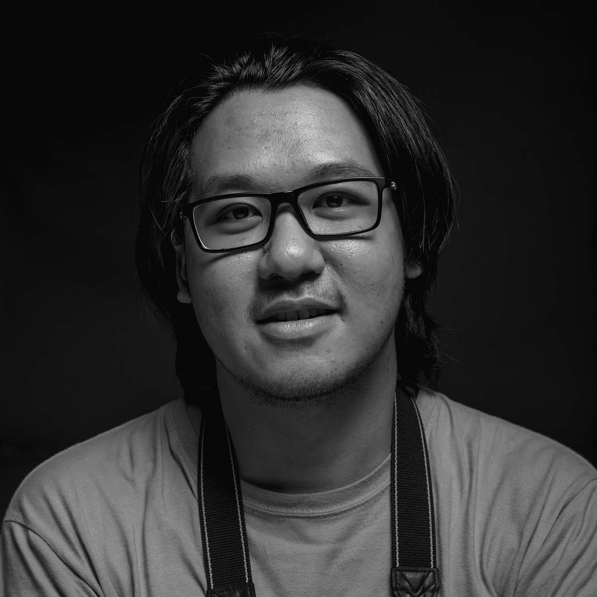 black-and-white grayscale photography of man wearing eyeglasses and crew-neck shirt face