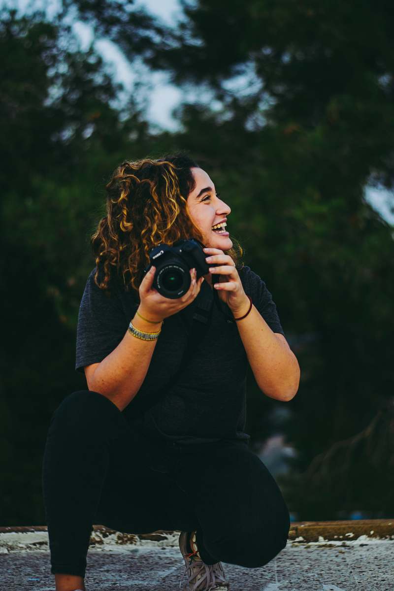 person kneeling woman holding bridge camera camera