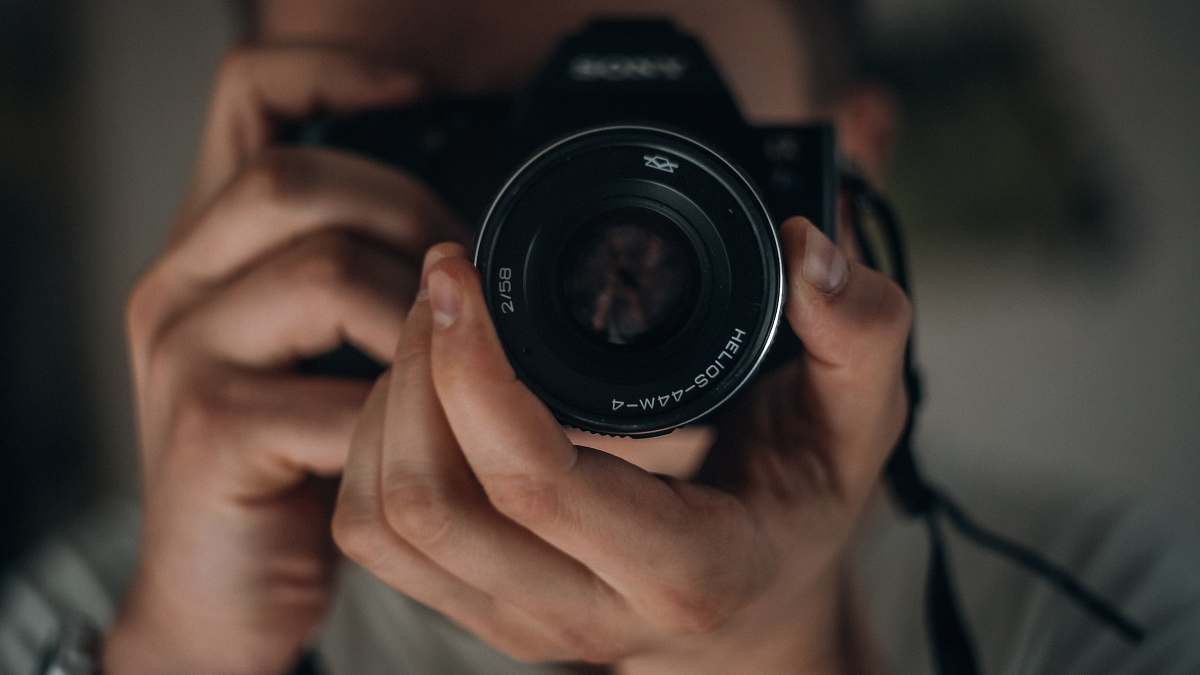 electronics man holding DSLR camera camera