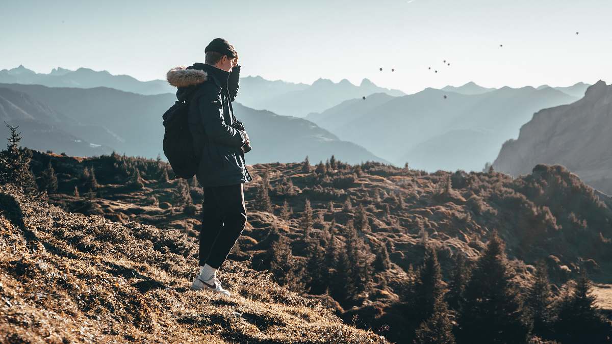 person man in black jacket on hill outdoors