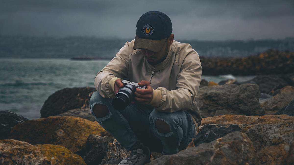 person man sitting on rock apparel