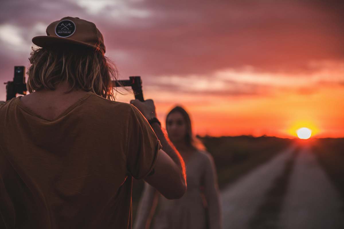 person man taking photo of woman on road photographer