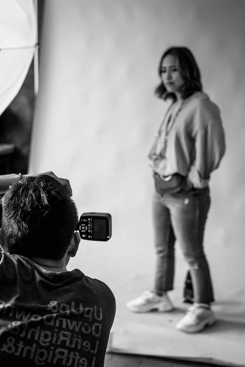 person man taking photo of woman standing black-and-white