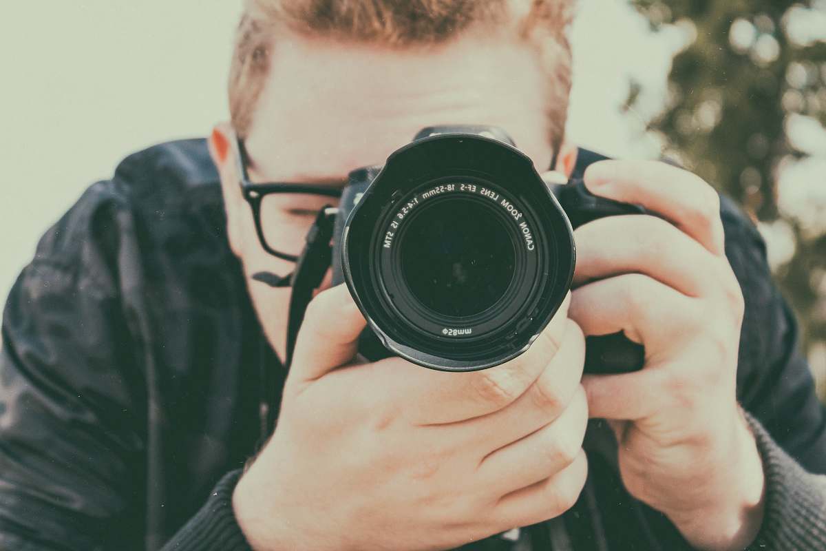 camera man taking photo using camera electronics