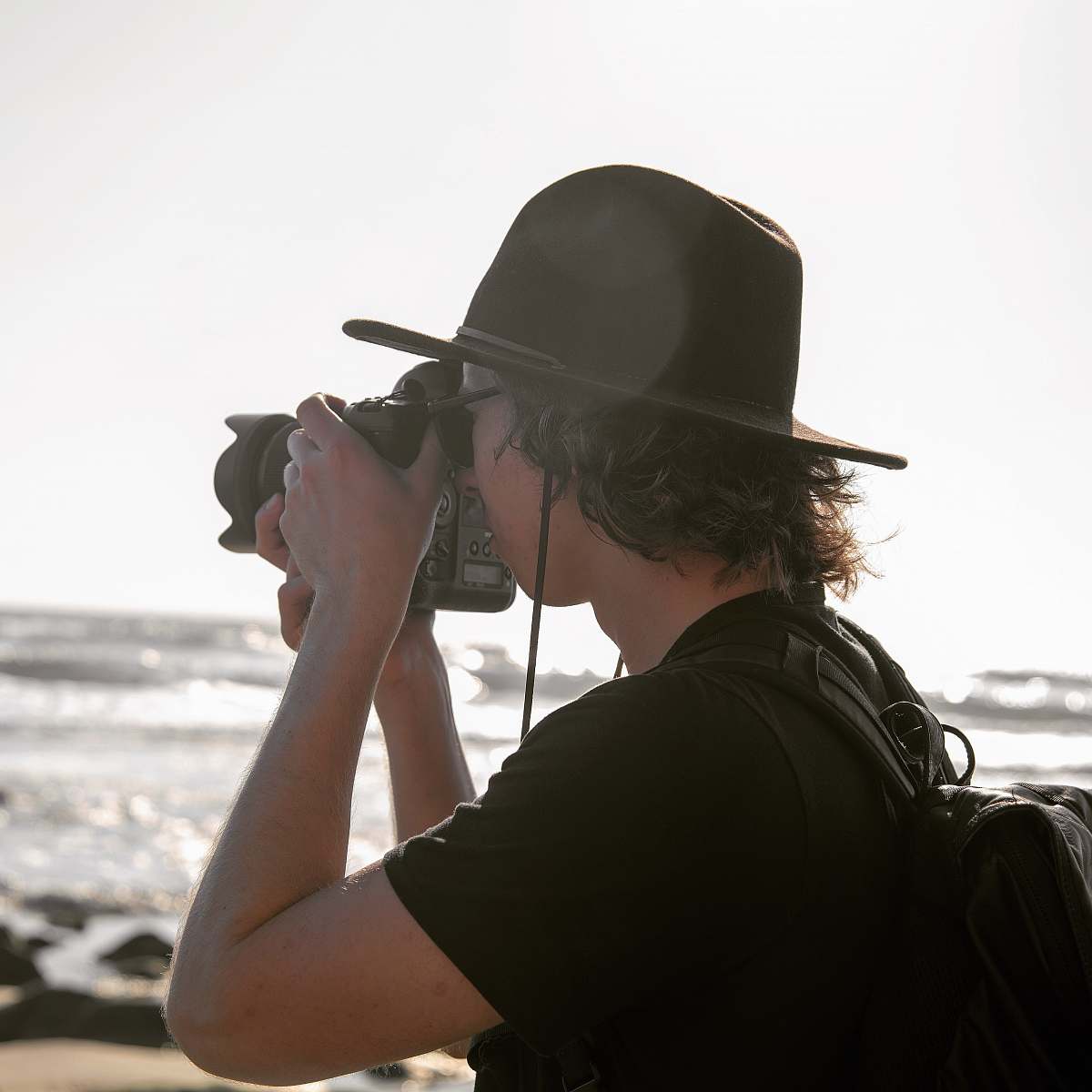 person man taking photo using DSLR camera apparel