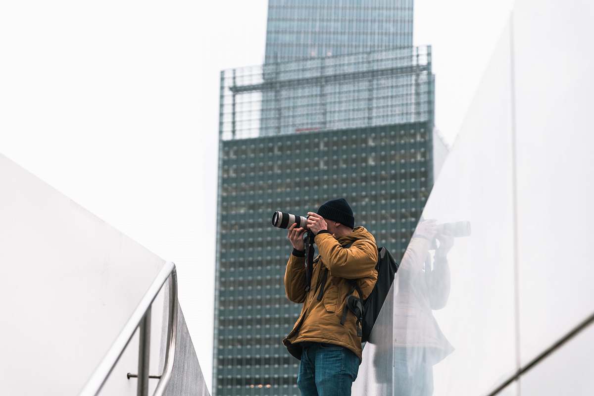 person man taking picture near building a daytime photography