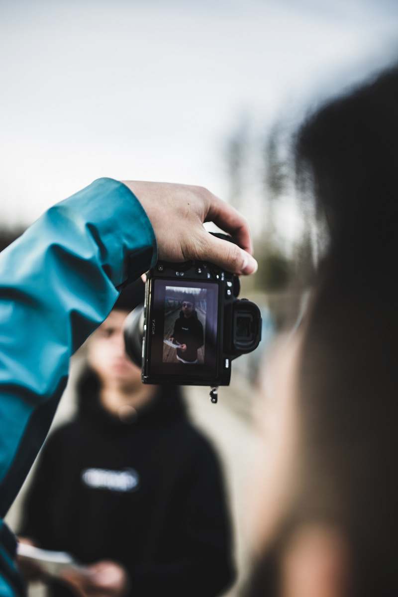 person person holding black DSLR camera camera