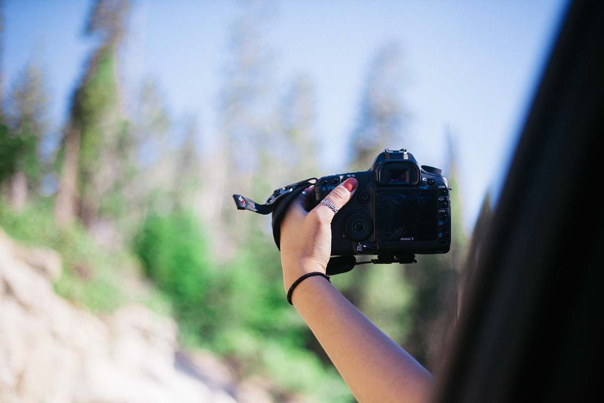 camera person holding DSLR camera electronics