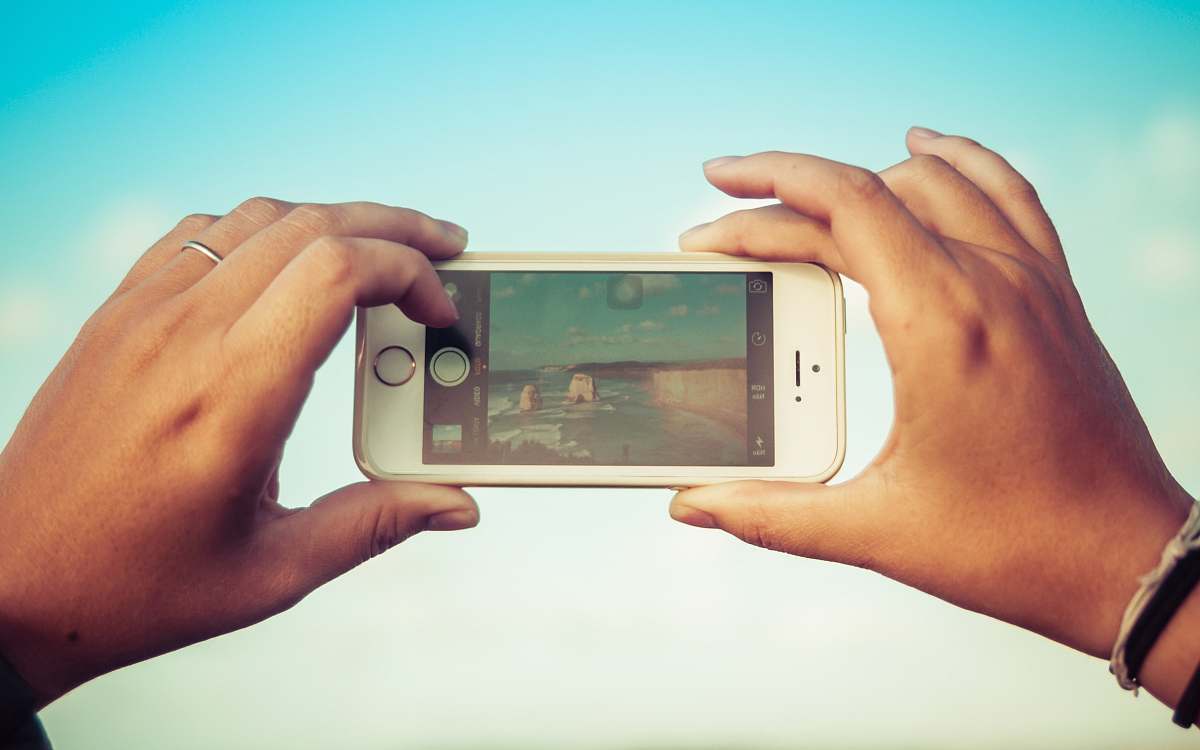 person person holding turned-on silver iPhone 5s cell phone