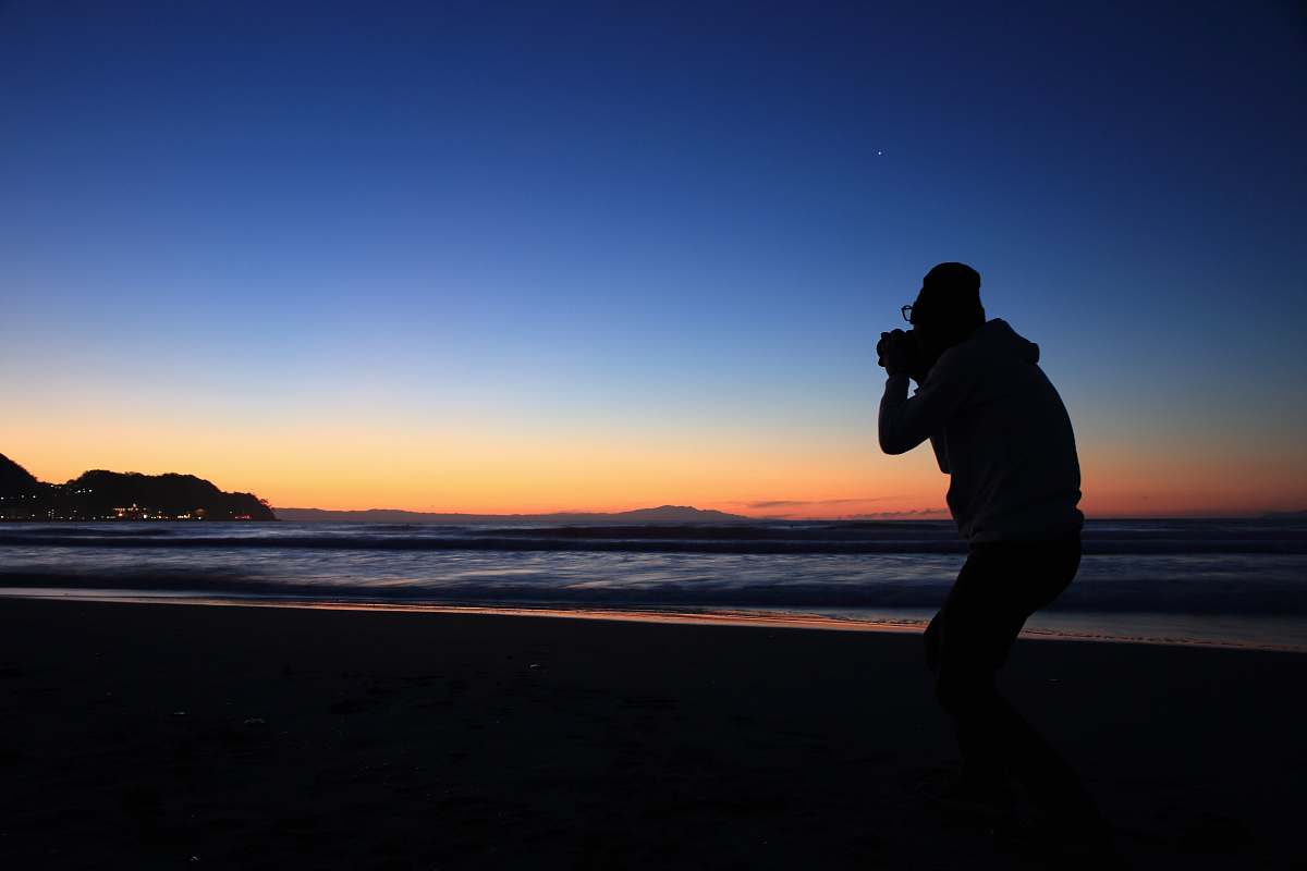 person silhouette of person standing near seashore photo