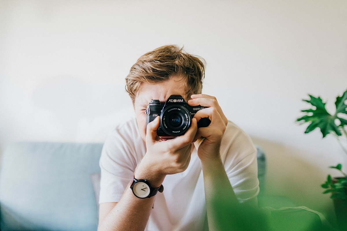 person sitting man taking picture camera