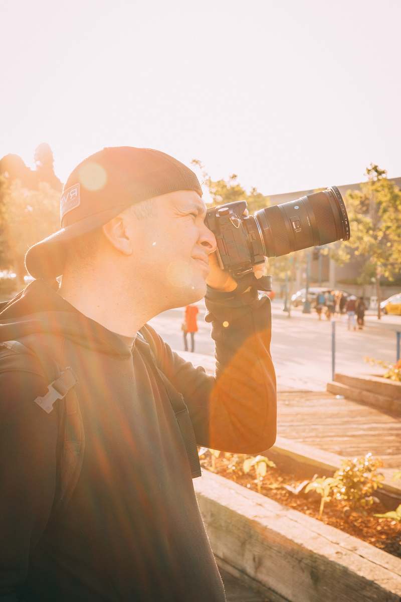 person unknown person holding black DSLR camera photo