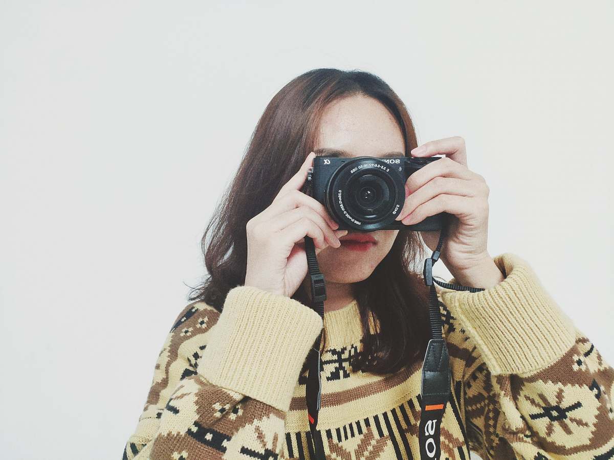 person woman holding camera camera