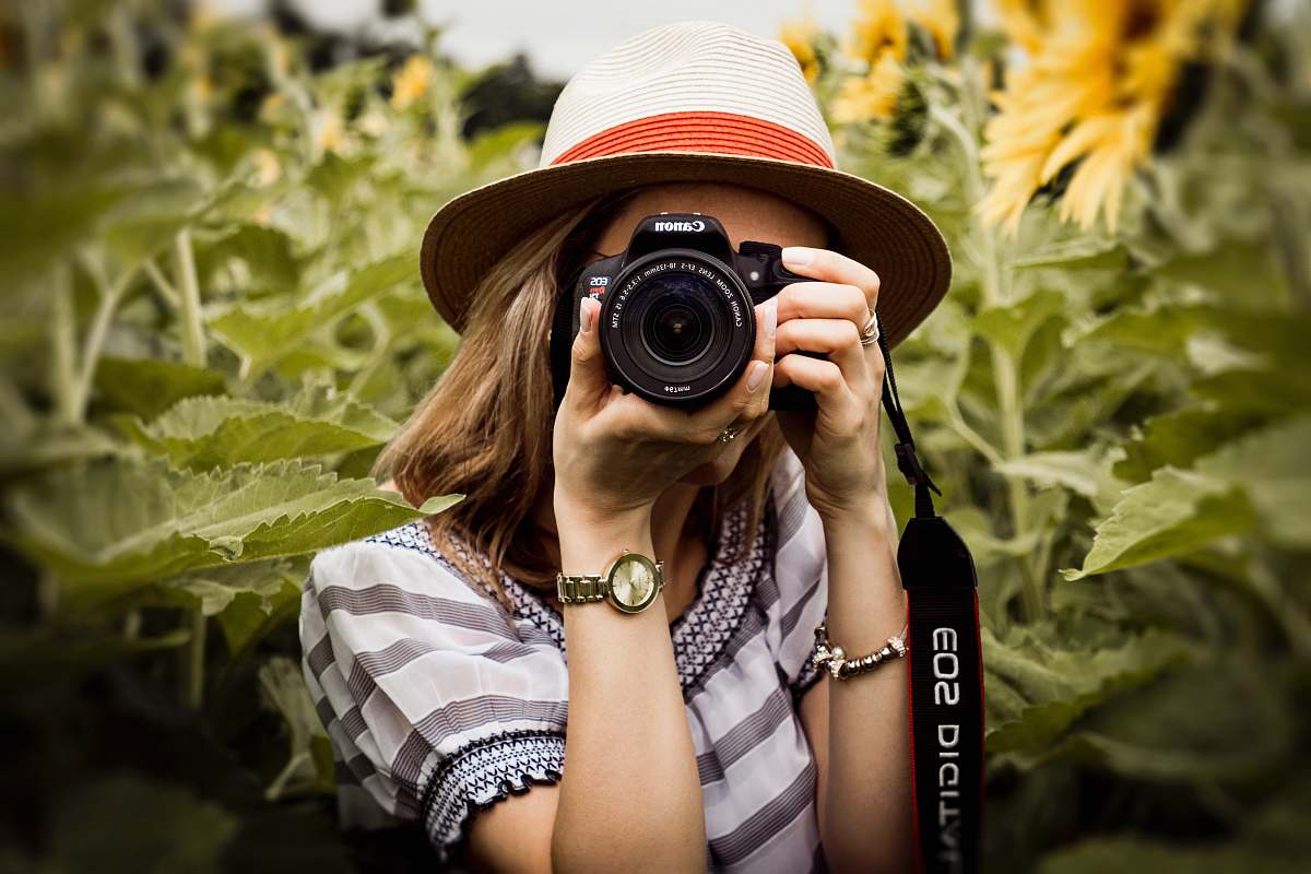 person woman taking photo of plants hat
