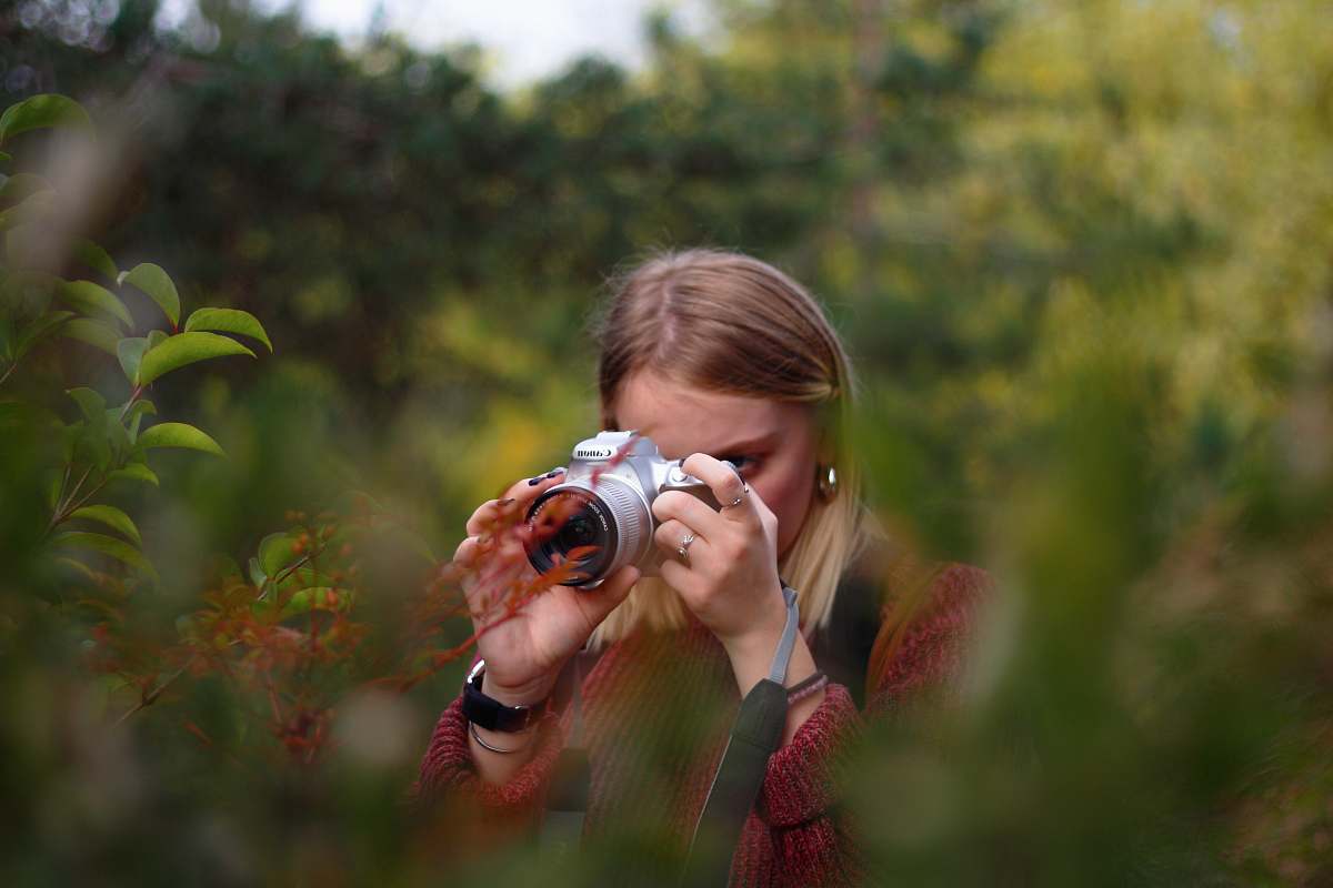 person woman taking photo using DSLR camera camera