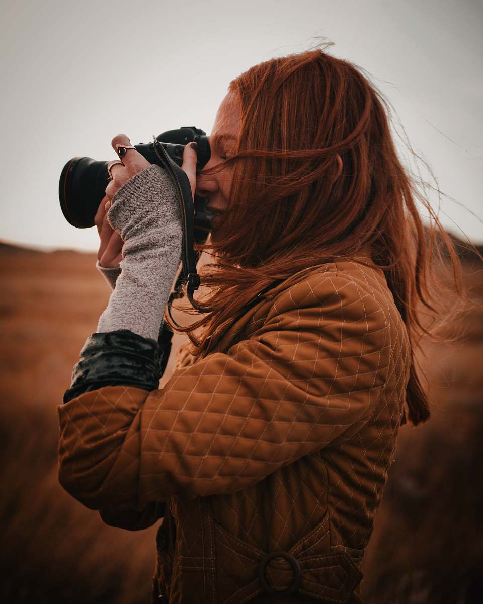 person woman using a DLSR camera photographer