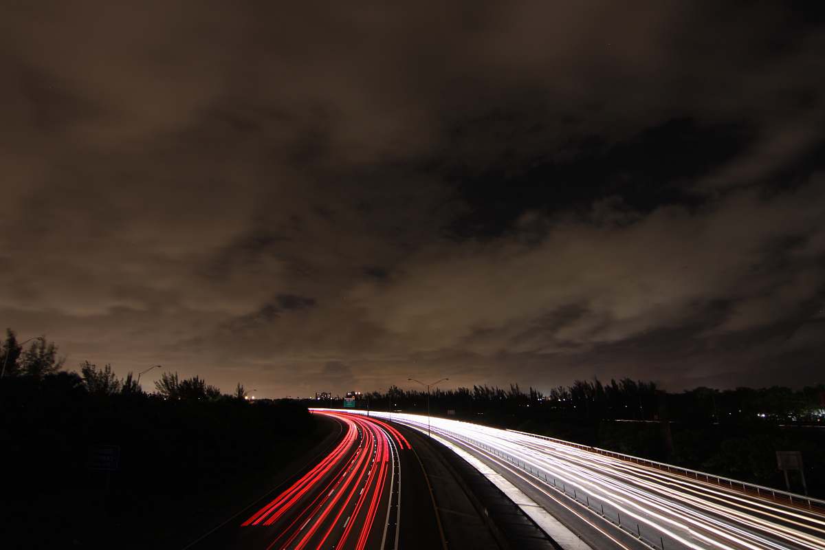 road timelapse photography of passing cars on road at nighttime freeway