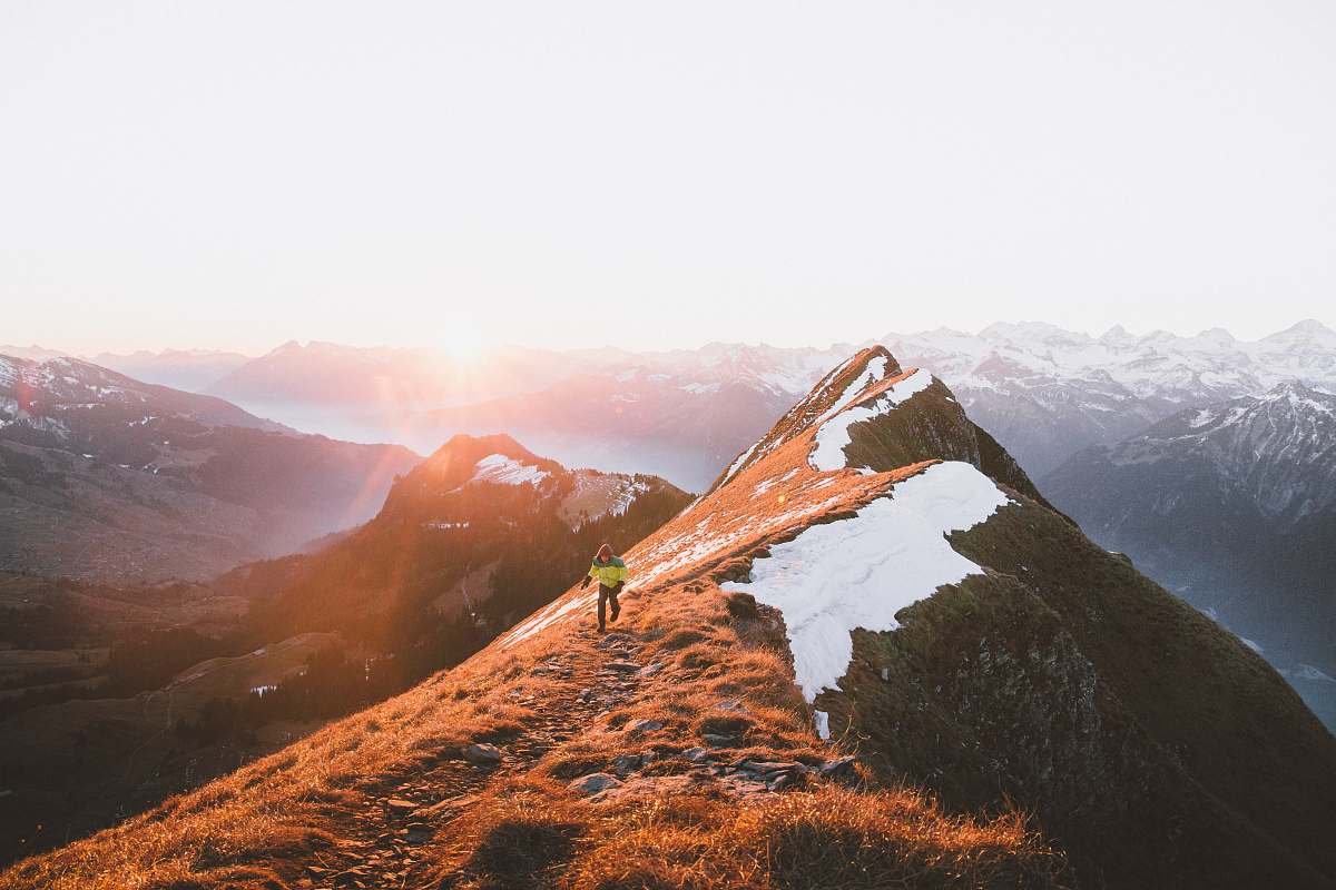 nature A person walking on a rocky path along the mountain ridge outdoors